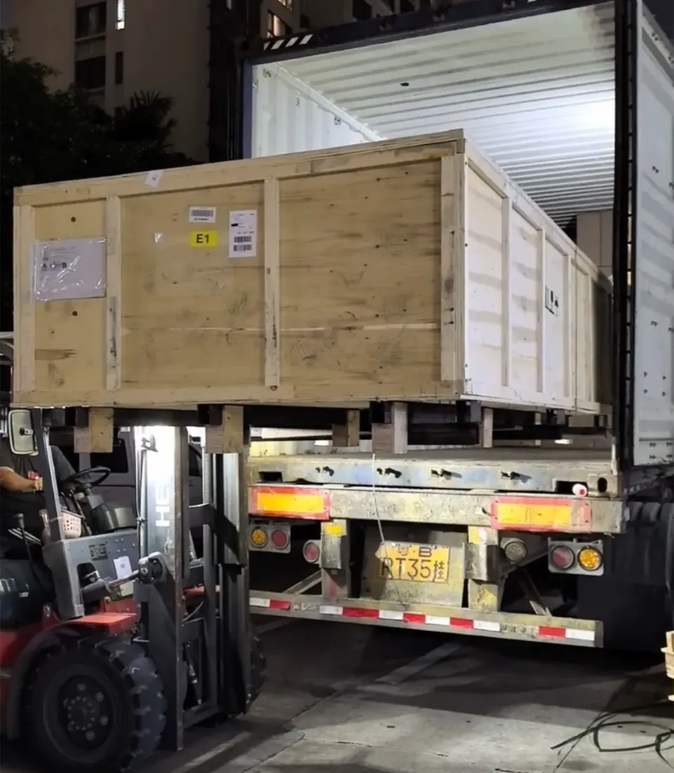 A forklift loading a wooden crate into a container